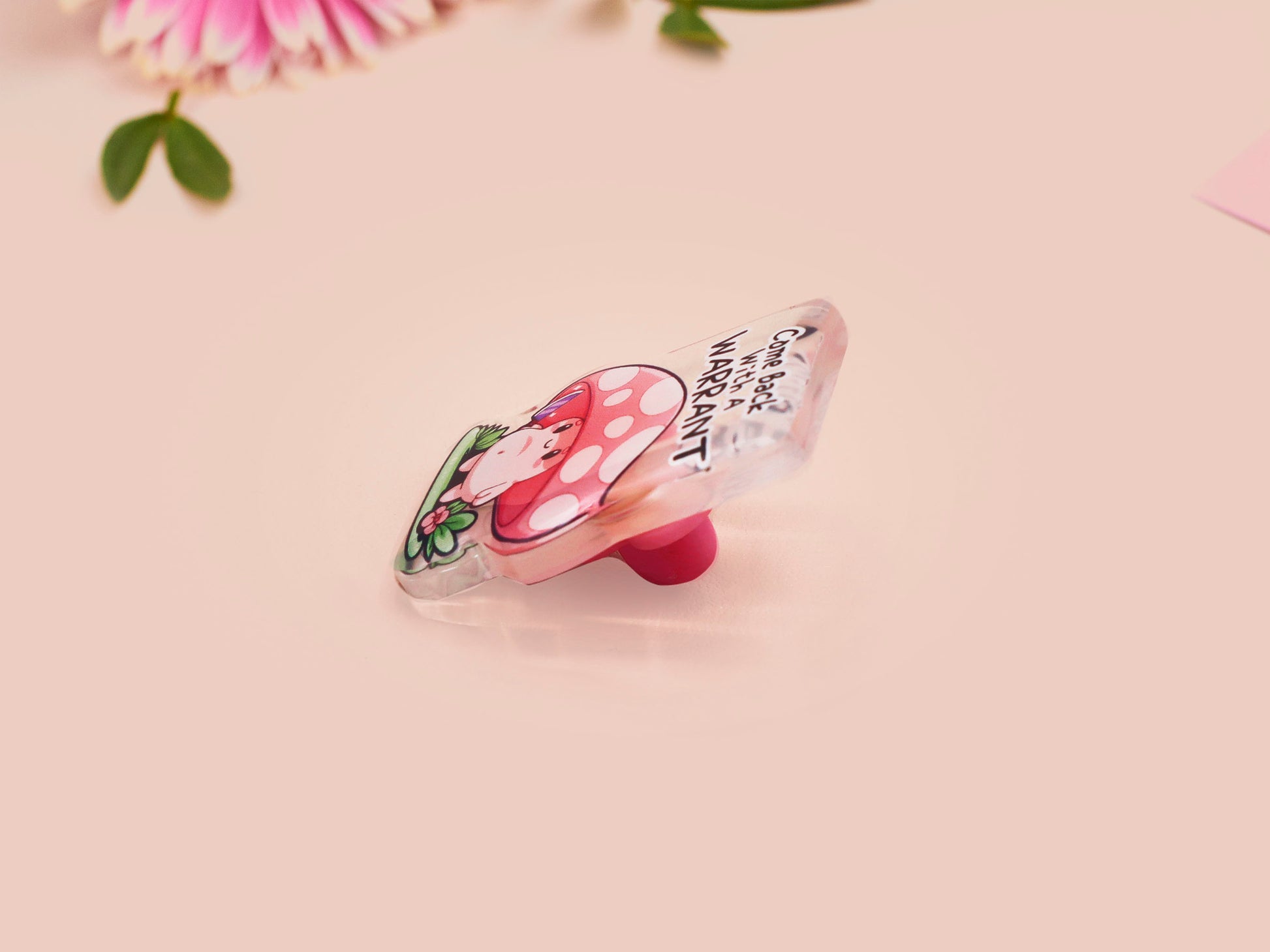 This cute transparent acrylic pin badge has a pink rubber heart shrimp pin-back clasp. The design is of a chibi cartoon mushroom with the text "Come back with a warrant."