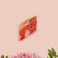 A clear acrylic pin badge with a pink heart-shaped pin back clasp. The design of the pin badge is of a cute singing cowboy cat from the viral internet meme with the song quote Country roads take me home to the place I belong