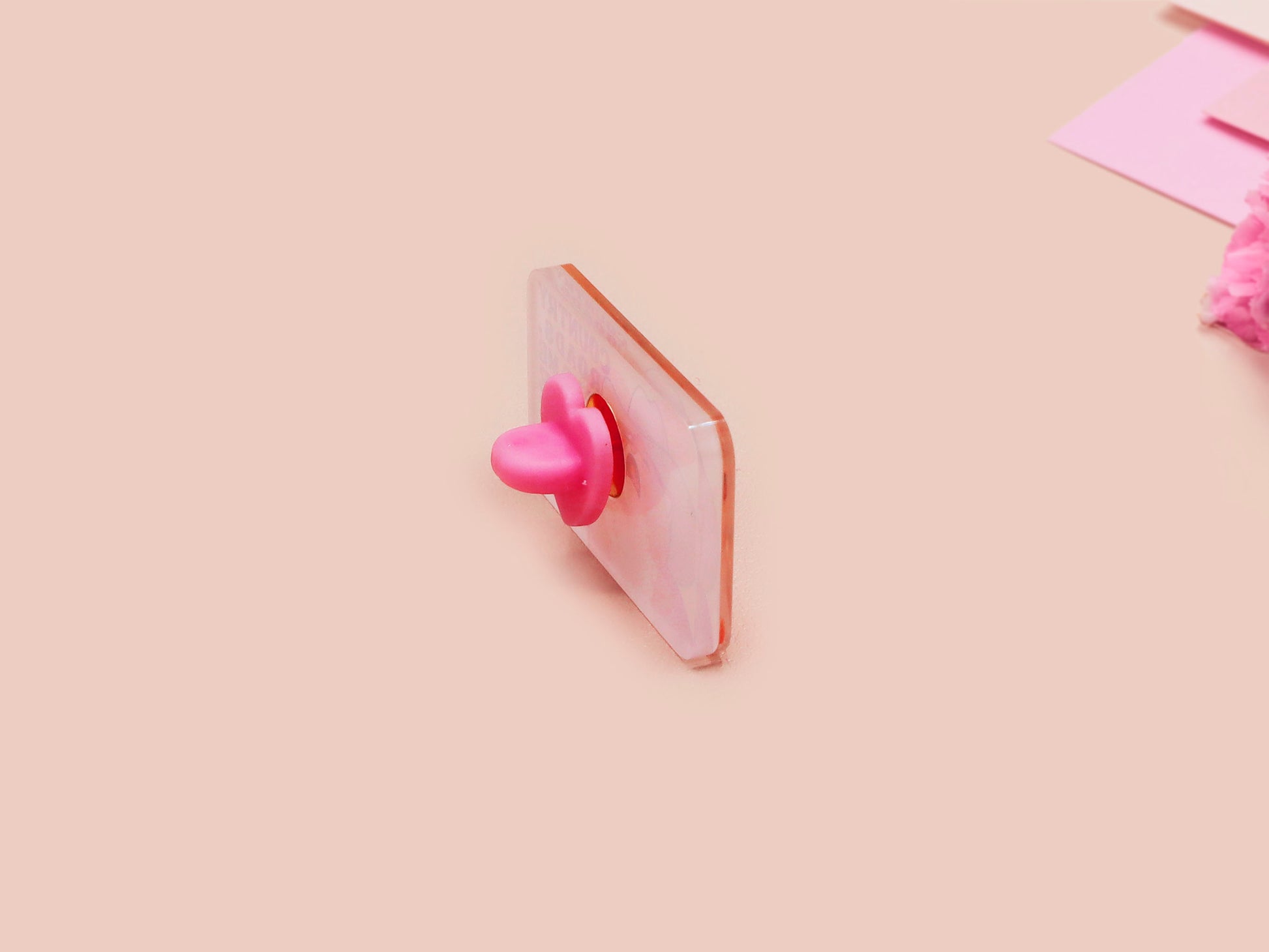A clear acrylic pin badge with a pink heart-shaped pin back clasp. The design of the pin badge is of a cute singing cowboy cat from the viral internet meme with the song quote Country roads take me home to the place I belong