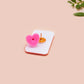 A clear acrylic pin badge with a pink heart-shaped pin back clasp. The design of the pin badge is of a cute singing cowboy cat from the viral internet meme with the song quote Country roads take me home to the place I belong