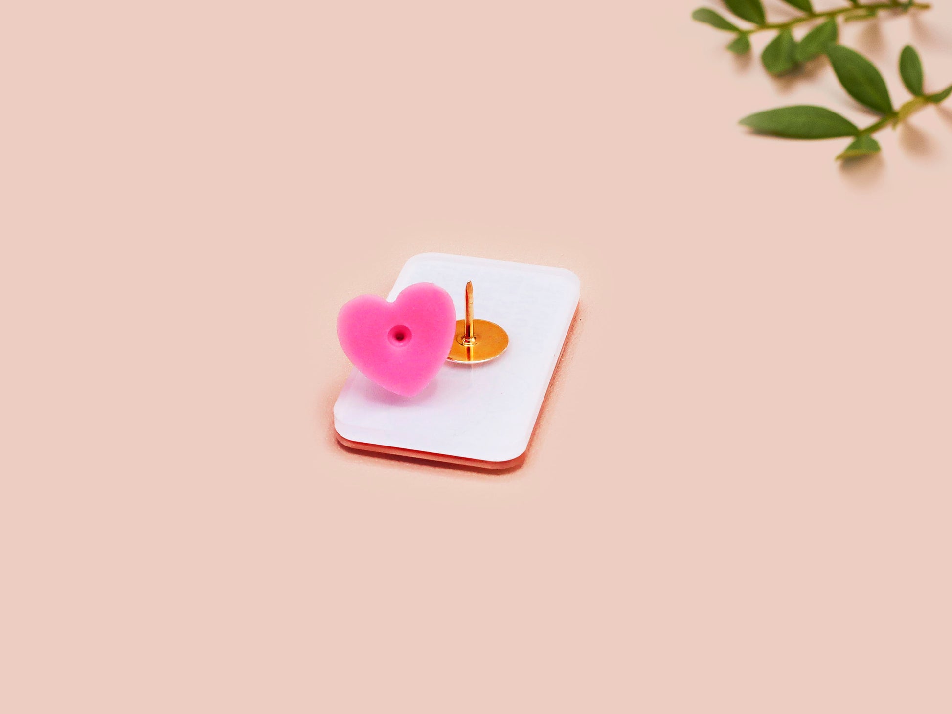 A clear acrylic pin badge with a pink heart-shaped pin back clasp. The design of the pin badge is of a cute singing cowboy cat from the viral internet meme with the song quote Country roads take me home to the place I belong