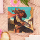 A square art print depicting a cowgirl gunslinger in a dramatic pose in the wild west outside a saloon.