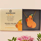 Adorable cute capybara with an orange on its head necklace made of wood and glitter pearlescent acrylic with a gold chain, displayed in a velvet gift box with a unique cute capybara sleeve design.