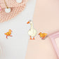 Three stickers of digitally illustrated cartoon ducks, one is a white adult duck the other are two small yellow ducklings