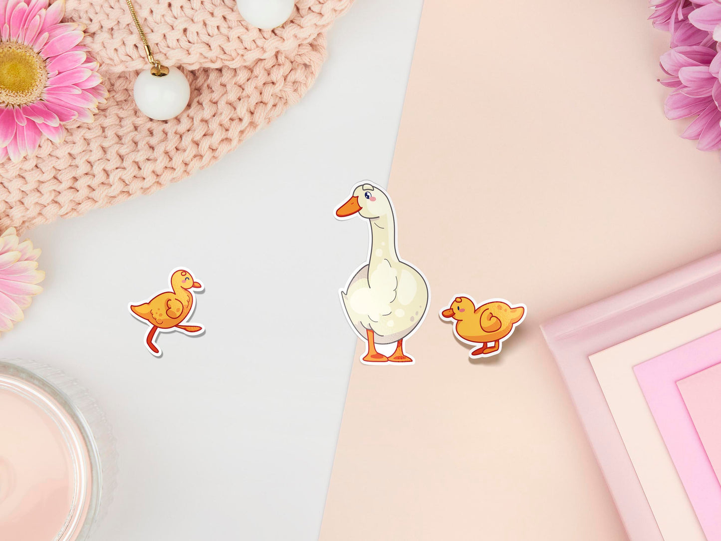 Three stickers of digitally illustrated cartoon ducks, one is a white adult duck the other are two small yellow ducklings