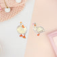 Two stickers of digitally illustrated cartoon of white ducks, one is wearing a crown the other has a pink heart