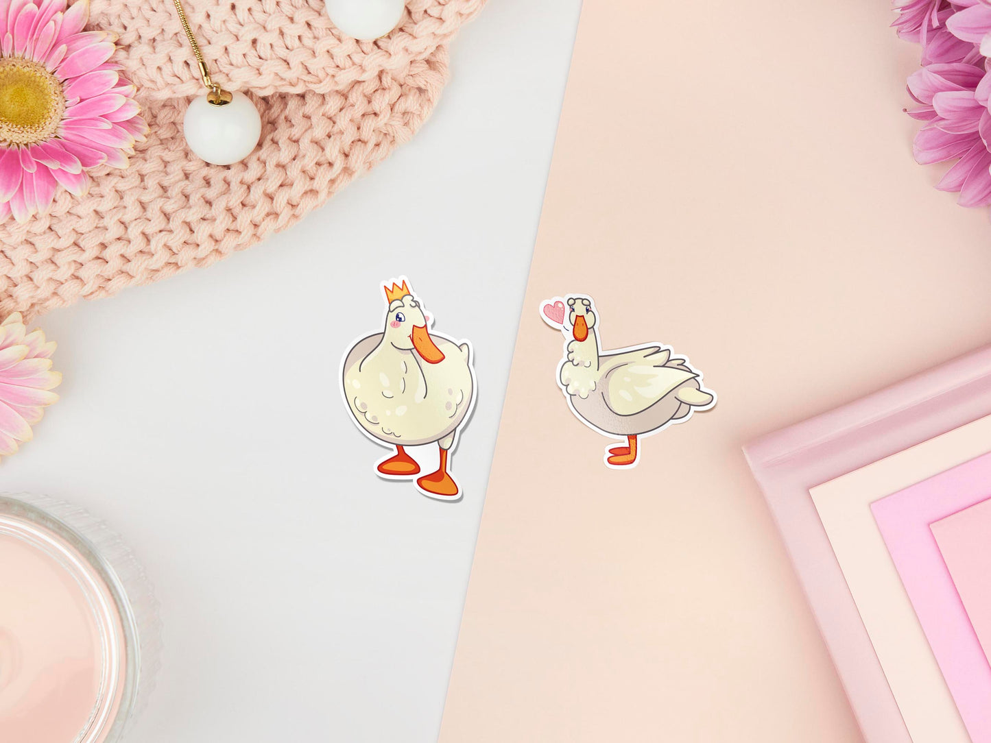 Two stickers of digitally illustrated cartoon of white ducks, one is wearing a crown the other has a pink heart