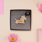 An adorable cute dachshund sausage dog brooch pin badge in a french outfit, a beret and a striped top, connected to a speech bubble that is engraved with the words oui oui! displayed in a velvet gift box with a unique cute dachshund sleeve design.
