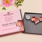 An adorable cute dachshund sausage dog necklace in a french outfit, a beret and striped top, connected to a speech bubble that is engraved with the words oui oui! displayed in a velvet gift box with a unique cute dachshund sleeve design.