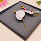 An adorable cute goose with a bell and pink bow necklace made of wood and glitter pearlescent acrylic with a gold chain is displayed in a velvet gift box with a unique cute goose sleeve design.