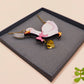 An adorable cute goose with a bell and pink bow necklace made of wood and glitter pearlescent acrylic with a gold chain is displayed in a velvet gift box with a unique cute goose sleeve design.