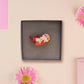 An adorable cute otter holding a clam seashell with a pearl inside brooch pin badge made of wood and glitter pearlescent acrylic with a gold chain is displayed in a velvet gift box with a unique cute otter sleeve design.