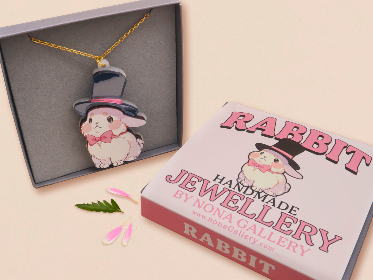 Adorable cute white bunny rabbit wearing a top hat and now tie necklace made of wood and mirror acrylic with a gold chain, displayed in a velvet gift box with a unique cute rabbit sleeve design.