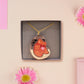 An adorable shy pangolin aardvark holding a heart necklace made of wood and glitter mirror acrylic with a gold chain is displayed in a velvet gift box with a unique cute Pangolin sleeve design.