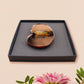 An adorable shy pangolin aardvark holding a heart brooch pin badge made of wood and glitter mirror acrylic with a gold chain is displayed in a velvet gift box with a unique cute Pangolin sleeve design.