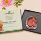 An adorable shy pangolin aardvark holding a heart necklace made of wood and glitter mirror acrylic with a gold chain is displayed in a velvet gift box with a unique cute Pangolin sleeve design.