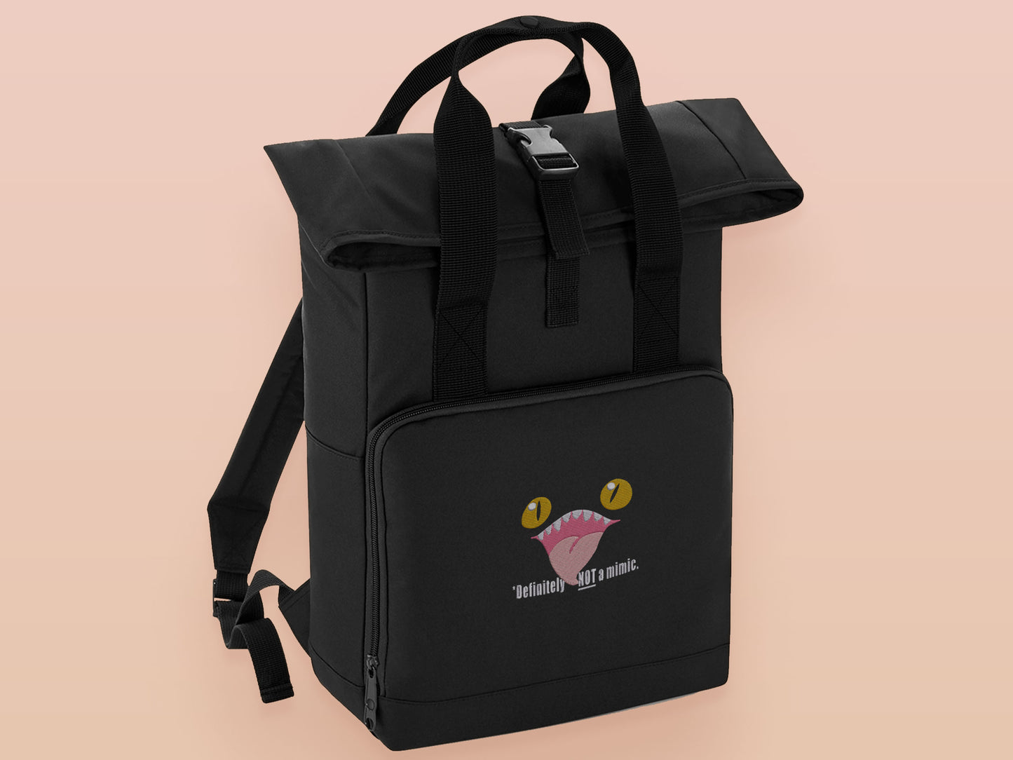 Black roll top backpack with a front pocket and an embroided mimic chest face cryptid design with the text *definetley not a mimic
