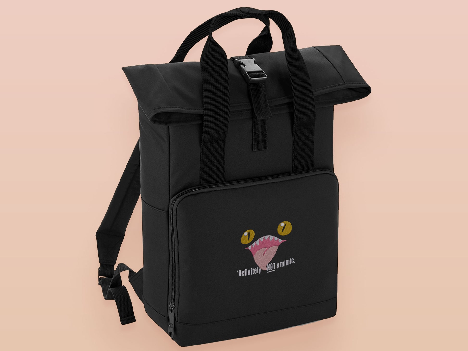 Black roll top backpack with a front pocket and an embroided mimic chest face cryptid design with the text *definetley not a mimic