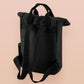 Black roll top backpack with a front pocket and an embroided mimic chest face cryptid design with the text *definetley not a mimic