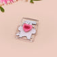 Cute transparent acrylic pin badge with a pink heart-shaped pin back clasp. The design of the badge is a chibi hench and buff cat with the quote Did you justPSPSPSPSPST my gurl?!