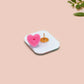 A clear acrylic pin badge with a pink heart-shaped pin back clasp. The design of the pin badge is of a cute relaxing capybara in water with a face mask with the quote don't worry be cappy.