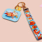 Acrylic epoxy blue capybara spa keychain with a large acrylic charm of a capybara floating in water relaxing with a face mask with the quote don't worry be cappy, a smaller charm of a cute rubber duck and a matching capybara spa day lanyard.
