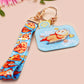 Acrylic epoxy blue capybara spa keychain with a large acrylic charm of a capybara floating in water relaxing with a face mask with the quote don't worry be cappy, a smaller charm of a cute rubber duck and a matching capybara spa day lanyard.