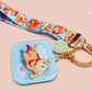 Acrylic epoxy blue capybara spa keychain with a large acrylic charm of a capybara floating in water relaxing with a face mask with the quote don't worry be cappy, a smaller charm of a cute rubber duck and a matching capybara spa day lanyard.