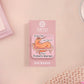 A cute transparent acrylic pin badge with a pink heart-shaped rubber clasp pin back. The design of the pin badge is a cartoon orange worm on a sting sitting on a sofa chaise lounge with the titanic quote Draw Me Like One of Your French Worms
