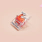 A cute transparent acrylic pin badge with a pink heart-shaped rubber clasp pin back. The design of the pin badge is a cartoon orange worm on a sting sitting on a sofa chaise lounge with the titanic quote Draw Me Like One of Your French Worms