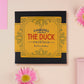 A wooden and glitter acrylic necklace with gold chain in a black box of a cute family of ducks two adult white ducks and four yellow ducklings playing and splashing in the water