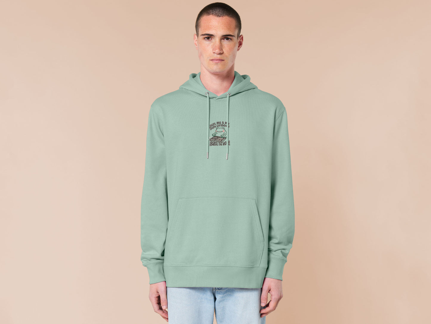 An embroidered green hoodie design of a cute frog happily looking at his binder of tcg trading cards surrounded by the quote Just Me And My Shiny Cardboard Against The World