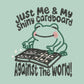 An embroidered green t-shirt design of a cute frog happily looking at his binder of tcg trading cards surrounded by the quote Just Me And My Shiny Cardboard Against The World