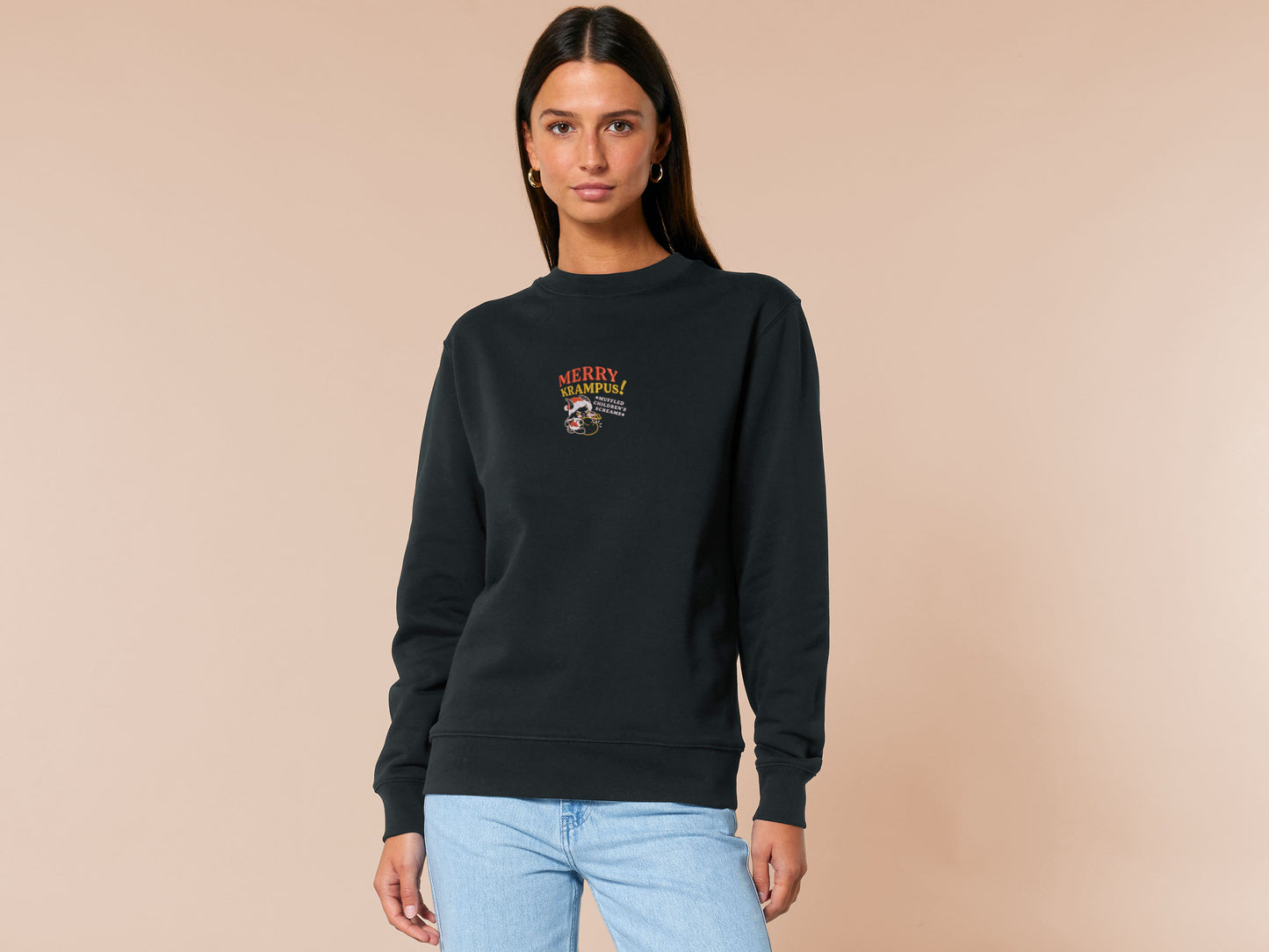 A black crew neck long sleeve sweater, with an embroidered chibi krampus christmas demon holdign a sack and the quote Mery Krampus! Muffled Children's screams