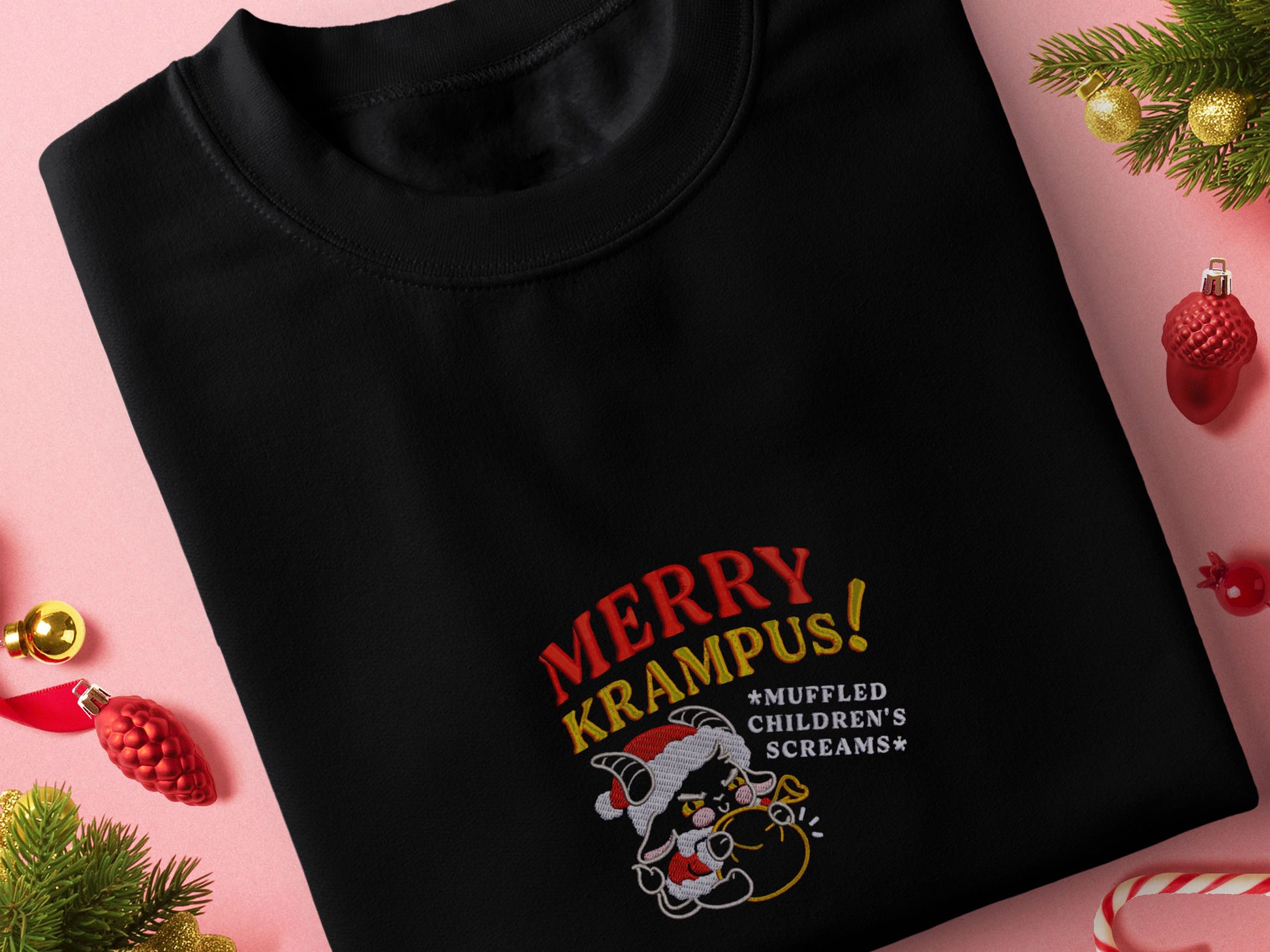 A black crew neck long sleeve sweater, with an embroidered chibi krampus christmas demon holdign a sack and the quote Mery Krampus! Muffled Children's screams