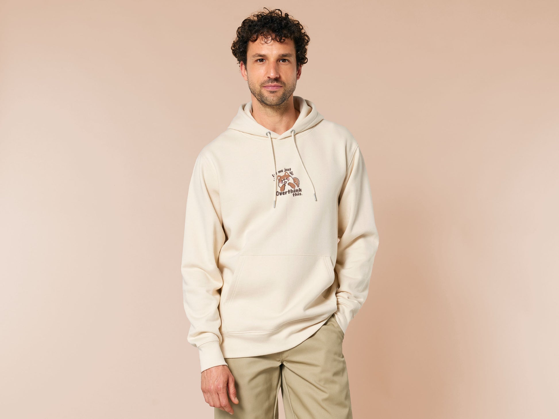 A cream crew neck long sleeve hoodie, with an embroidered design of a cute shiba inu dog looking stressed surrounded by the quote Let Me Just Overthink This