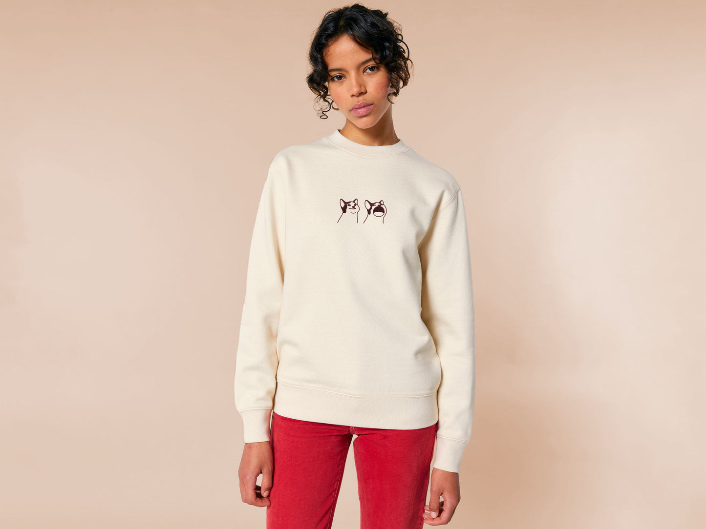 A cream crew neck long sleeve sweater, with an embroidered brown thread design of a cute popcat the cat meme reaction twitch emote