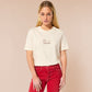 A cream crew neck short sleeve t-shirt, with an embroidered brown thread design of a cute daschund dog looking concerend surrounded by the quote In This Economy?