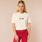 A cream crew neck short sleeve t-shirt, with an embroidered brown thread design of a cute popcat the cat meme reaction twitch emote