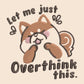 A cream crew neck short sleeve t-shirt, with an embroidered design of a cute shiba inu dog looking stressed surrounded by the quote Let Me Just Overthink This