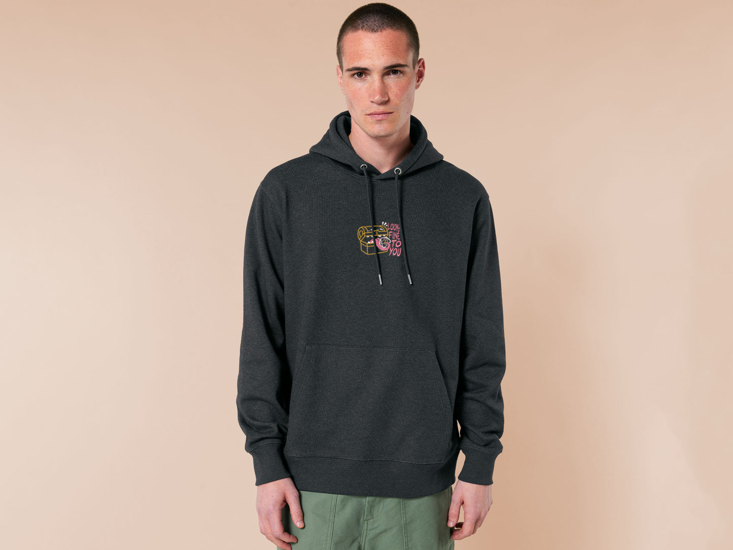 A dark grey crew neck long sleeve hoodie, with an embroidered cute chibi mimic chest holding a D20 dice rolled a one and the quote Looks fine to you.