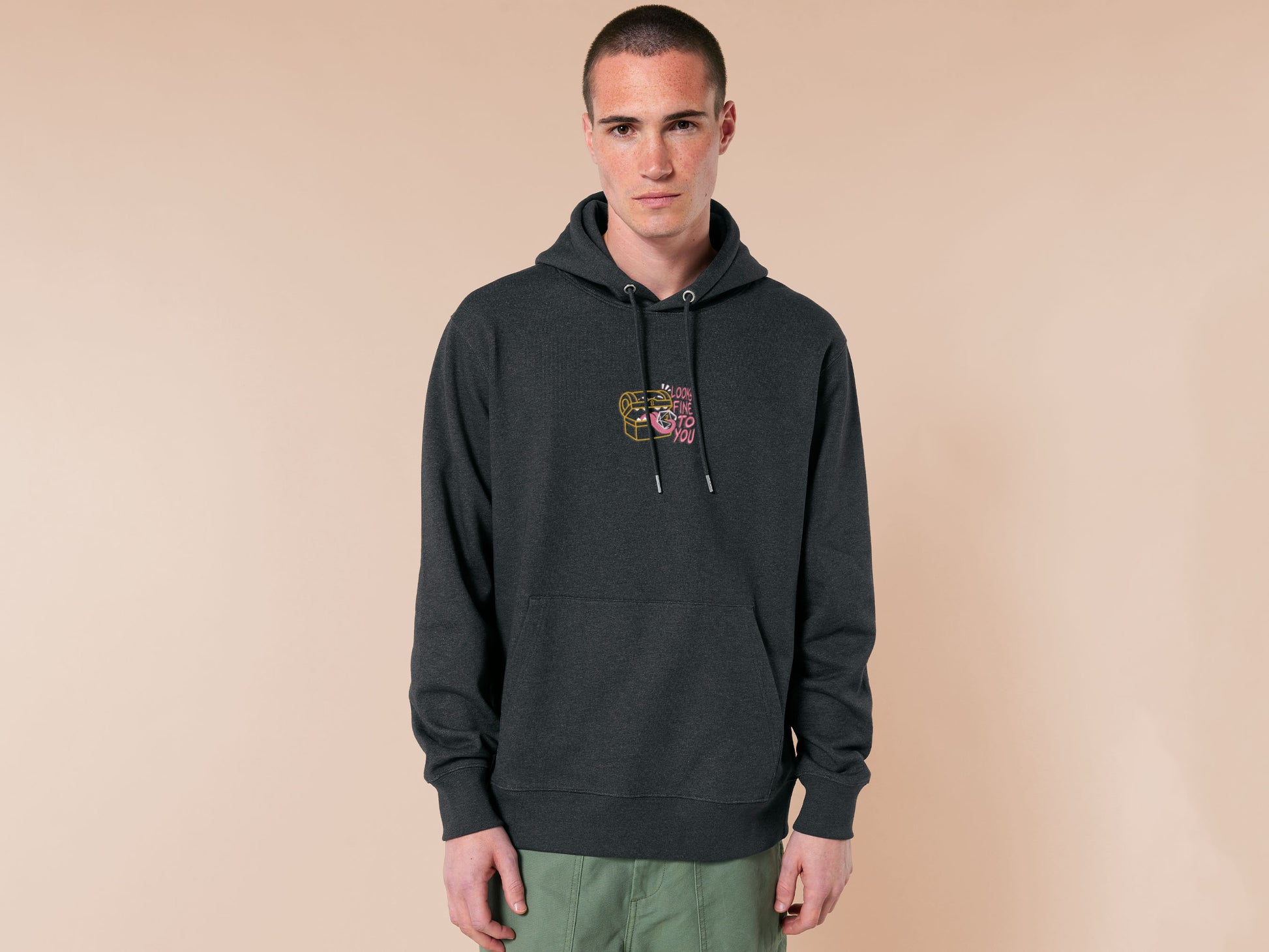 A dark grey crew neck long sleeve hoodie, with an embroidered cute chibi mimic chest holding a D20 dice rolled a one and the quote Looks fine to you.