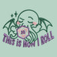 An embroidered green t-shirt design of a cute Cthullu with a D20 dice surrounded by the quote This Is How I Roll
