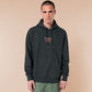 A dark grey long sleeve hoodie, with an embroidered chibi mothman and the quote Live Lamp Lurk.
