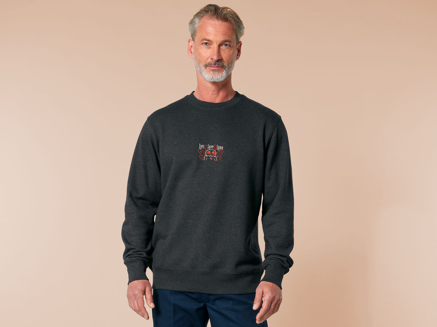 A dark grey crew neck long sleeve sweater, with an embroidered chibi mothman and the quote Live Lamp Lurk.