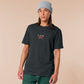 A dark grey crew neck short sleeve t-shirt, with an embroidered chibi mothman and the quote Live Lamp Lurk.