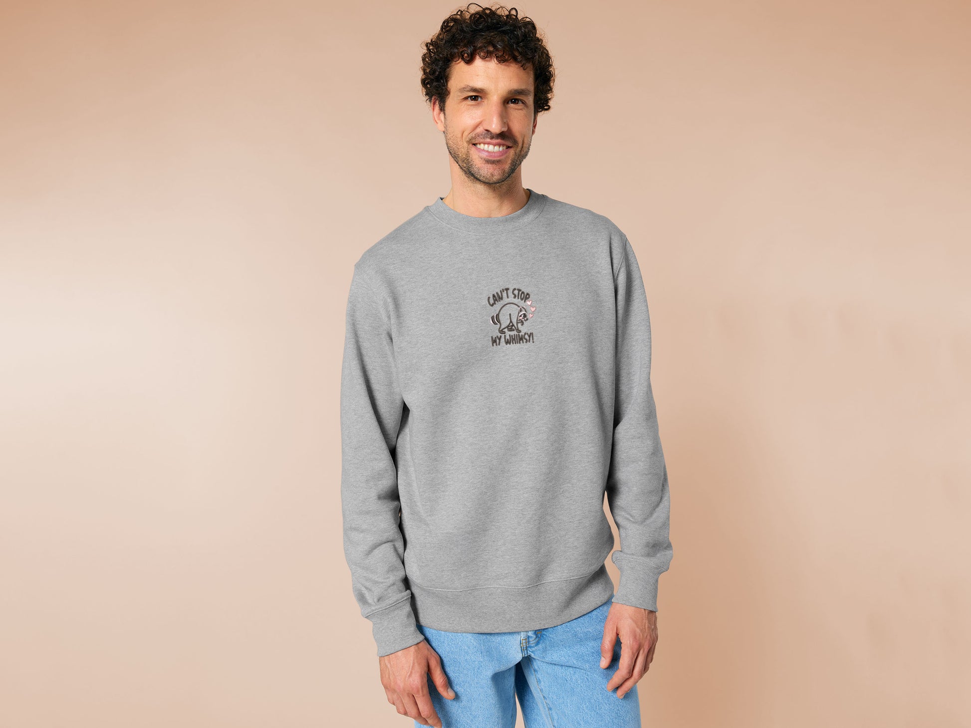An Embroidered light grey sweater design of a cute Jimothy the viral disabled raccoon and the quote can't stop my whimsy!
