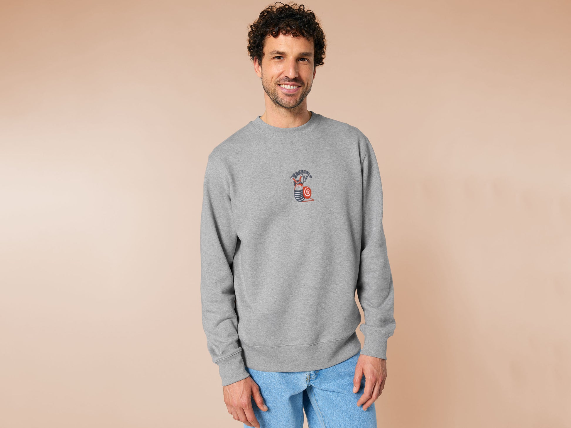An Embroidered light grey sweater design of a cute chib french snail with the quote sacreblu!