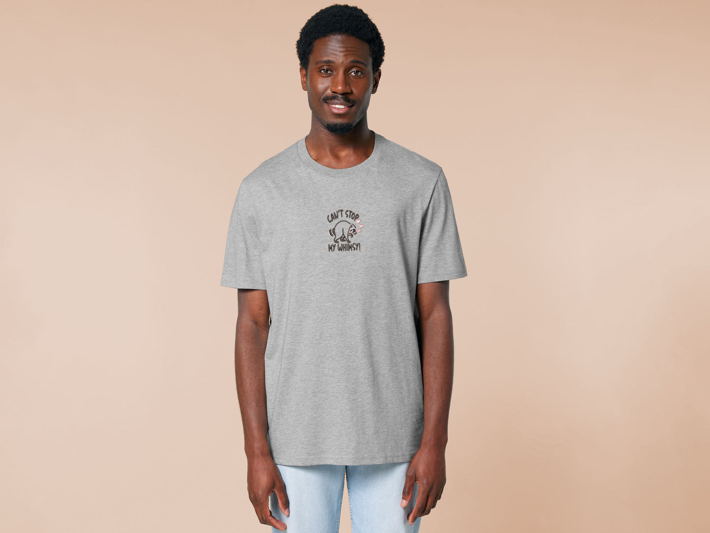 An Embroidered light grey t-shirt design of a cute Jimothy the viral disabled raccoon and the quote can't stop my whimsy!