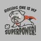 An Embroidered light grey t-shirt design of a cute chibsuper dog wearing a red cape panicked at a dice with the text rolling one is my superpower